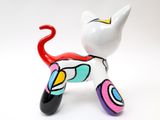 a colorful cat figurine sitting on a white surface