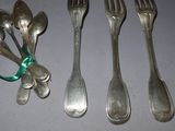 several spoons and forks are lined up on a table