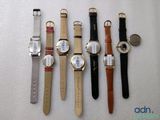 several different watches are lined up on a white surface