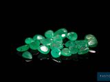a close up of a bunch of green gems on a black surface