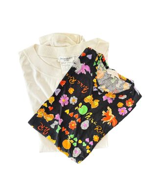 two t - shirts with flowers on them are laying next to each other