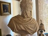 a bust of a man sitting on a table in a room