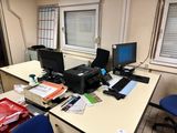 un bureau sur lequel se trouvent deux écrans d'ordinateur et une imprimante