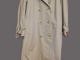 the trench coat is hanging on a hanger on the wall