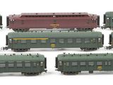a lot of green and red train cars on a white surface