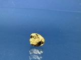 une pièce d'or posée sur une table bleue