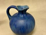a blue vase that is sitting on a table