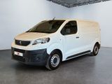 La camionnette blanche est garée dans une grande pièce d'un immeuble.
