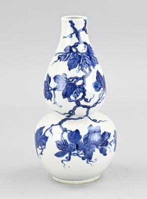 deux vases bleus et blancs posés l'un sur l'autre sur une table