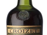 Une vieille bouteille de Crozzer Bonatate est posée sur une surface blanche.