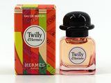un petit flacon de parfum posé à côté d'une boîte