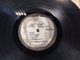 vinyl record with a picture of john lennon on it on a table