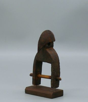 une vieille figurine en bois représentant un homme avec un chapeau sur la tête