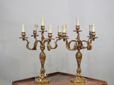 paire de chandeliers anciens en laiton posés sur un socle en bois