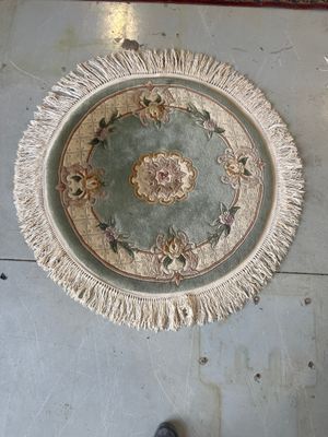 a rug on the floor in a room with a person standing next to it