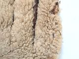 un gros plan sur la laine d'un mouton posée sur une surface blanche