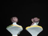 two white vases sitting on top of a black table next to each other