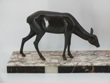 statue of a black deer on a marble base on a white background