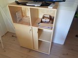 a small cabinet with a laptop on top of it and a television on top of it