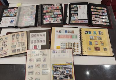de nombreux timbres posés sur une table, à côté d'un livre ouvert