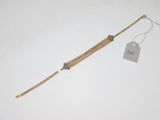 un bracelet en chaîne d'or auquel est attachée une plaque
