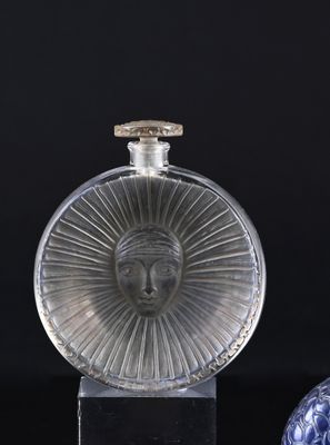 two glass bottles with a face on them sitting on a black surface