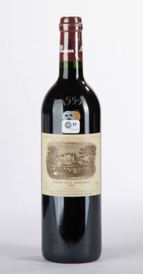 une vieille bouteille de vin rouge posée sur une table blanche