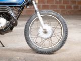 a blue motorcycle parked in front of a brick wall