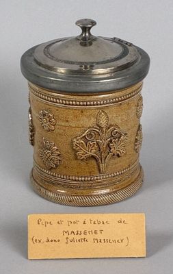 a small silver and gold container with a label on it