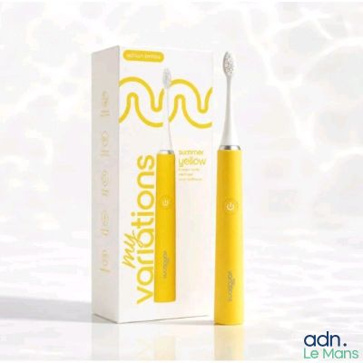 une brosse à dents jaune posée à côté d'un tube de dentifrice jaune