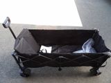 a black wagon with a baby in it on the street