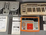un clavier, un synthétiseur, un lecteur de cassettes et d'autres appareils électroniques posés sur une table