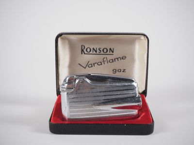 a small silver lighter in a case on a white surface