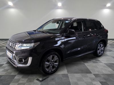 un 4x4 noir garé sur un sol en damier dans un garage