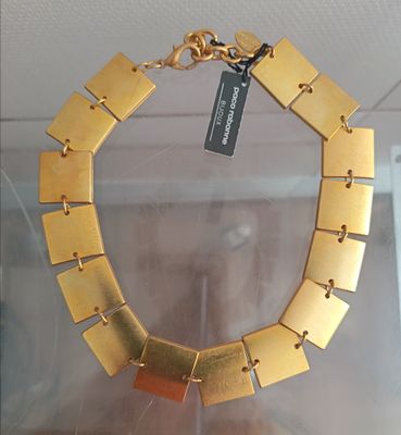 gold plated necklace on display in glass case with tag