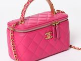 a close up of a pink purse with a chain around it