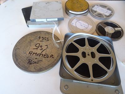une table sur laquelle sont posées de nombreuses bobines de films anciens