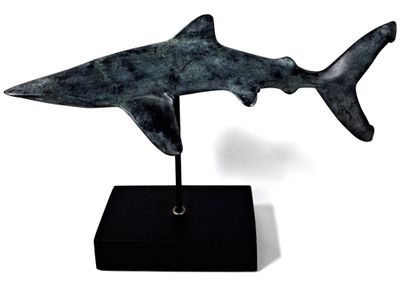 statue of a shark on a black base on a white background