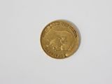 a close up of a gold coin on a white surface