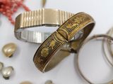 many different types of bracelets and rings on the table