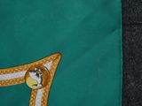 a close up of a green cloth with a gold and white design on it