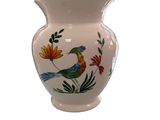 a white vase with a bird and flowers on it