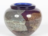 a vase with a blue lid sitting on a white surface