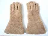 deux paires de gants marron posées sur une surface blanche