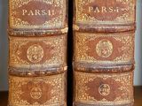 several old books are stacked on top of each other on a table