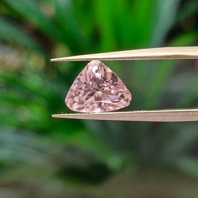 someone is holding a pair of pliers with a pink diamond in it
