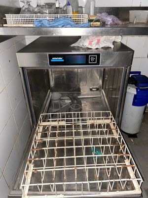 an image of a dirty dishwasher in a dirty kitchen