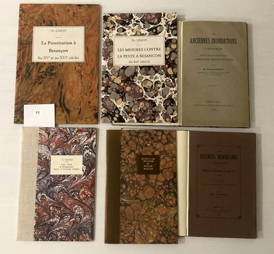 plusieurs livres sont alignés sur une table à fond blanc