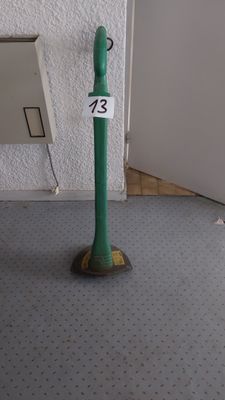 un poteau vert sur lequel est inscrit un numéro, devant une porte