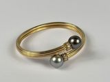 un gros plan d'une bague ornée de deux perles